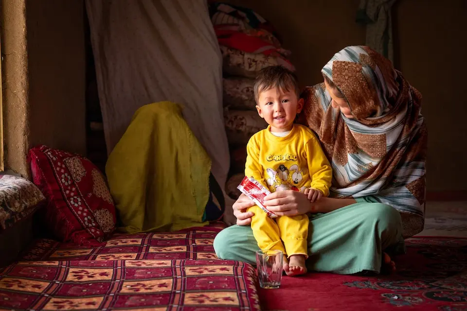 A mother prepares to give her malnourished son ready-to-use therapeutic food (RUTF) provided by UNICEF in Daikundi Province, Afghanistan.