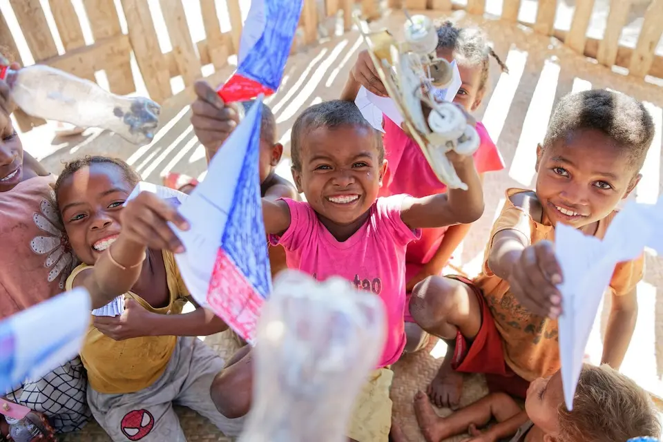 Children proudly show off paper toys inside a UNICEF-assisted safe space in Madagascar. © UNICEF / UN0887785 / Rindra Ramasomanana
