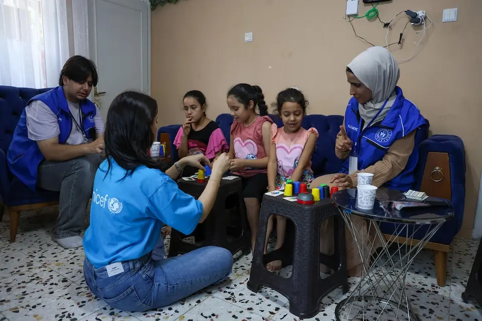 UNICEF-supported community volunteers in Türkiye lead kids in a game during a household visit.