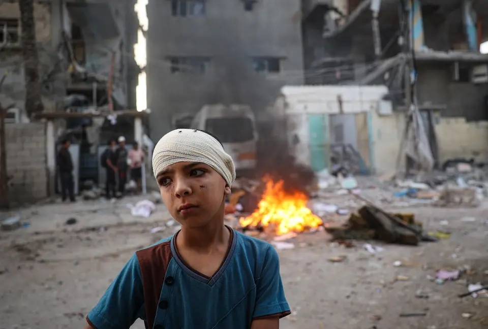 An injured boy stands in the wreckage near his house after an airstrike in Rafah, south of the Gaza Strip. © UNICEF / UNI820817 / Eyad El Baba