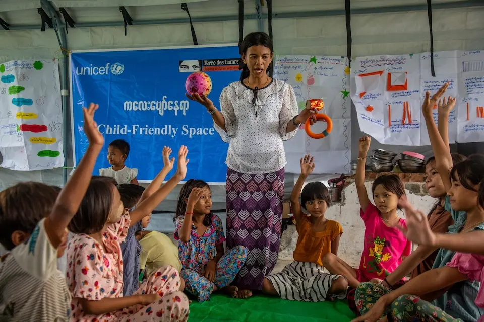 A child protection officer works with young kids in a child-friendly space tent provided by UNICEF in the Mandalay region of Myanmar. © UNICEF / UNI870647 / Nyan Zay Htet