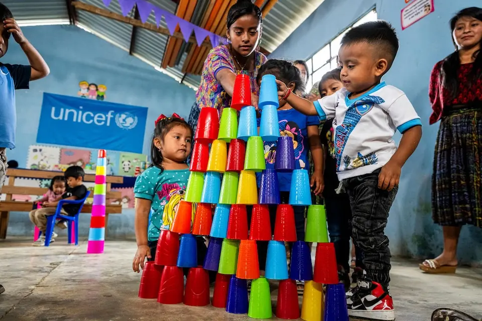 A 3-year-old boy builds a cup tower at a UNICEF-supported early childhood development center in Guatemala. 
