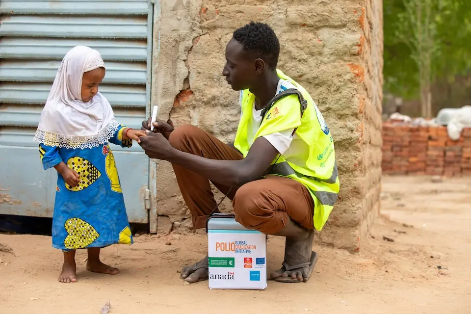 A UNICEF-supported vaccinator in Chad inks a little girl's finger to indicate she has received her polio vaccine.