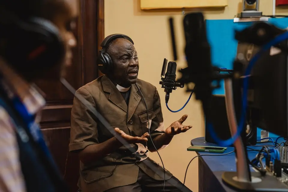 Yanga Reckem, pastor and Ebola survivor, speaks on a radio program in Bunia to spread awareness.