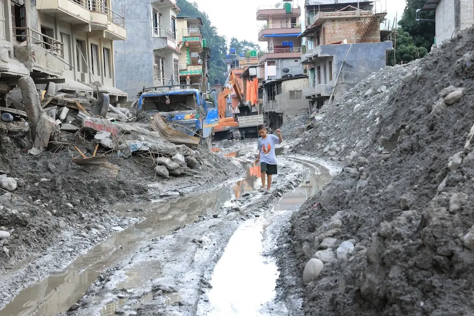 A 10-year-old boy walks through a flood-damaged street in Nuwakot, Nepal on Sept. 21, 2026.