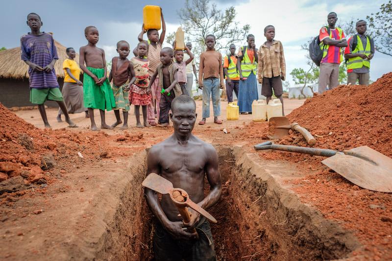 Justin in Uganda man digging latrine body shot