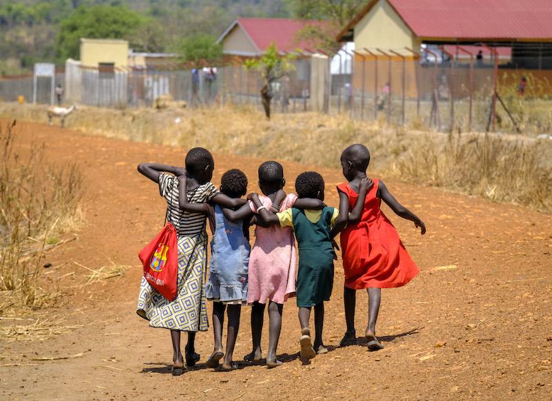 Justin in Uganda five girls walking away body shot