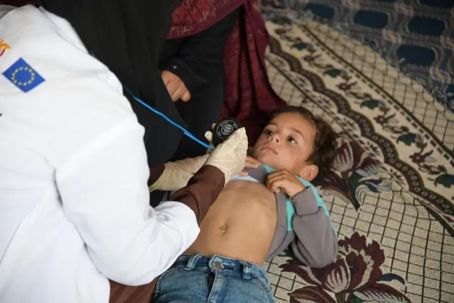 UNICDFE-supported community health worker, Basma Al-Astuh examines a child in the village of Dhayan in Yemen's Amran Governorate in 2020.. UNICDFE-supported community health worker, Basma Al-Astuh examines a child in the village of Dhayan in Yemen's Amran Governorate in 2020..