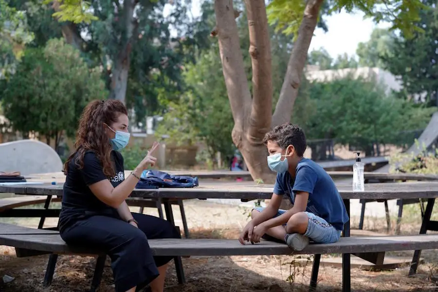 After the Beirut explosions in August 2020, 10-year-old Abdulkarim chats with a UNICEF-trained volunteer at a Child-Friendly Space set up in a municipal park in Karantina, a Beirut suburb. After the Beirut explosions in August 2020, 10-year-old Abdulkarim chats with a UNICEF-trained volunteer at a Child-Friendly Space set up in a municipal park in Karantina, a Beirut suburb.