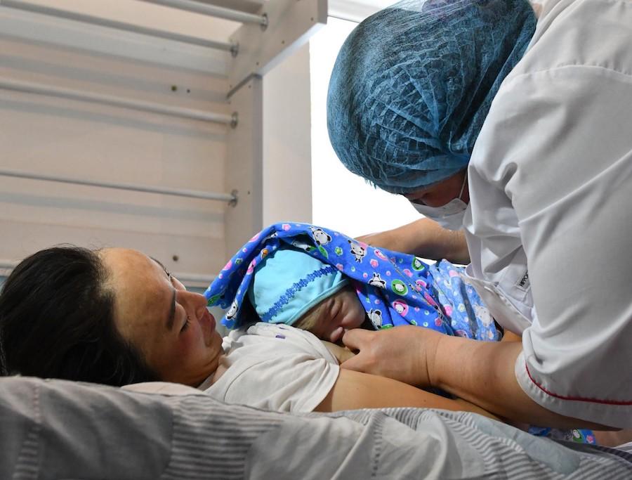 In Kyrgyzstan, Jiydegul's newborn son, Nurdan, is placed at her breast in Daroot Korgon Hospital. 
