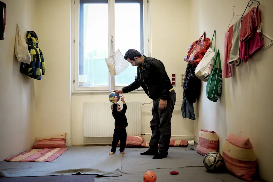 On 5 December 2015, 1-year-old Mohammad Taha Ibrahimi plays with his father, Abdul Anath Ibrahim, 32, in their room at an emergency shelter in Vienna. They are among refugees, primarily from the Syrian Arab Republic, Iraq and Afghanistan, who are living a On 5 December 2015, 1-year-old Mohammad Taha Ibrahimi plays with his father, Abdul Anath Ibrahim, 32, in their room at an emergency shelter in Vienna. They are among refugees, primarily from the Syrian Arab Republic, Iraq and Afghanistan, who are living a
