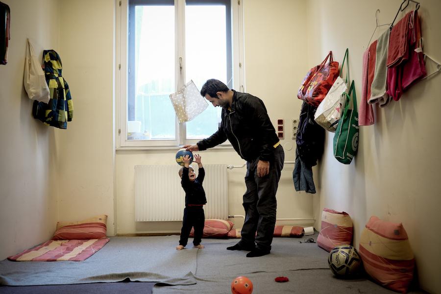 On 5 December 2015, 1-year-old Mohammad Taha Ibrahimi plays with his father, Abdul Anath Ibrahim, 32, in their room at an emergency shelter in Vienna. They are among refugees, primarily from the Syrian Arab Republic, Iraq and Afghanistan, who are living a