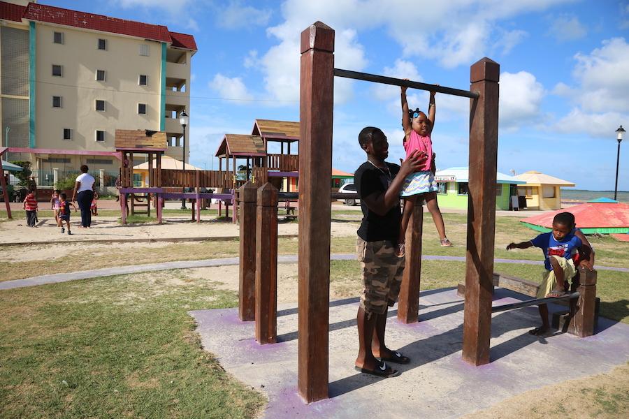 On 13 August 2016, 3-year-old Alishia (center) plays with her brother, 17-year-old Andrew, and her cousin, KJ, in a park by the water in Belize City.