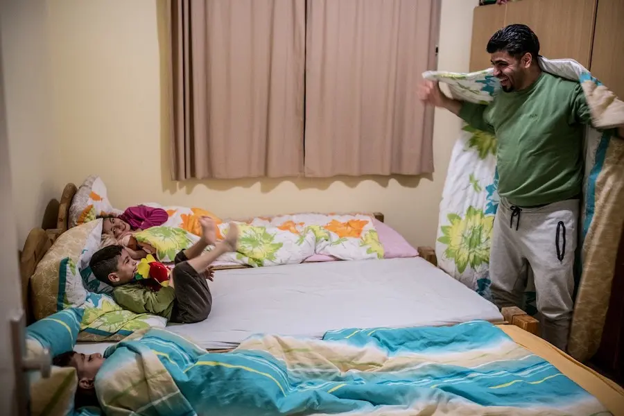 Father Tucking Kids in Bed