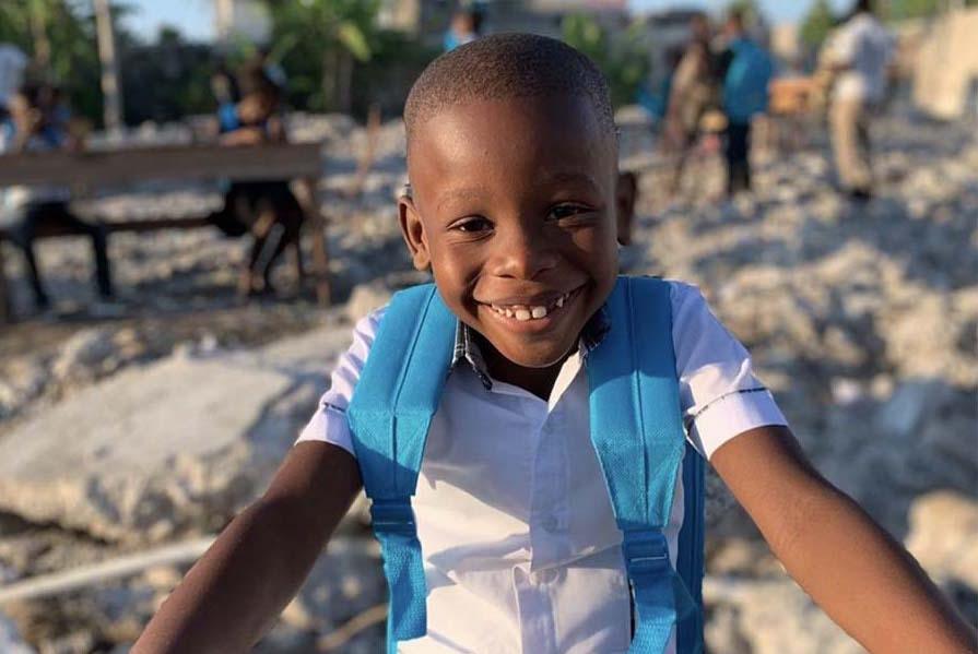 Child Smiling Wearing UNICEF Backpack