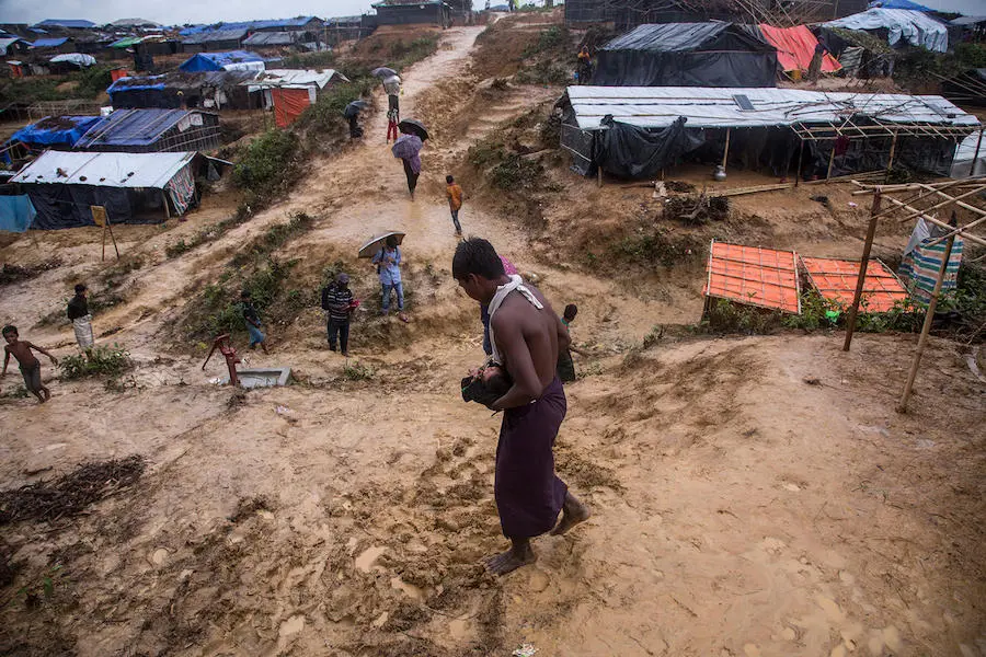 A boy carries his 4-day-old niece down a muddy slope in the sprawling Kutupalong camp for Rohingya refugees in Cox's Bazar Bangladesh in October 2017. A boy carries his 4-day-old niece down a muddy slope in the sprawling Kutupalong camp for Rohingya refugees in Cox's Bazar Bangladesh in October 2017.