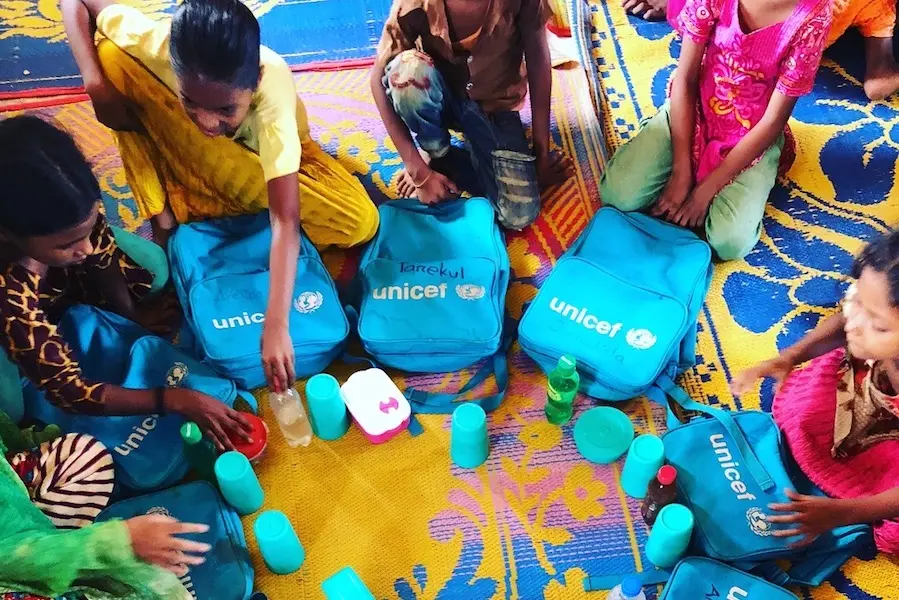 Children in a Rohingya refugee camp in Cox's Bazar, Bangladesh proudly carry their UNICEF backpacks filled with learning materials. unicef, bangladesh, rohingya, rohingya refugees, refugee camps, education, educating girls, humanitarian relief