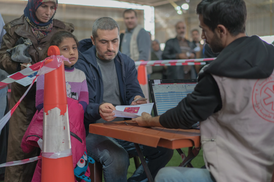 Ahmad, a Syrian refugee in Lebanon, plans to pay for his daughter's school transportation to school using the LOUISE common card, which administers cash transfers. 
