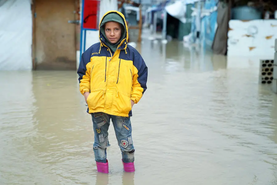 On 8 January 2019 in the Bekaa Valley, Lebanon, a young Syrian refugee stands in a flooded informal tented settlements struggle with dire conditions that have worsened after a strong storm hit Lebanon on 6 January. UNICEF, Syrian refugees, Lebanon, winter storm, humanitarian aid