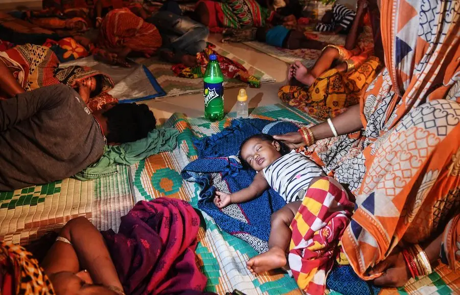 Families evacuated for safety rest at a temporary cyclone relief center in Puri in the eastern Indian state of Odisha on May 3, 2019, as Cyclone Fani approaches the Indian coastline. 
