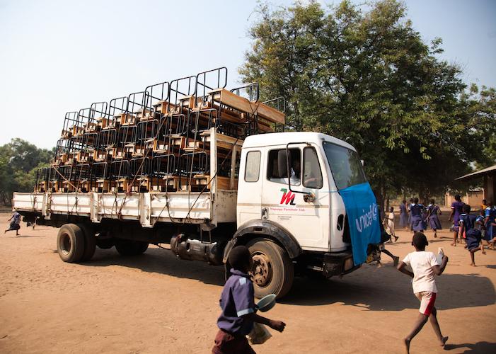 Students come running to see a new shipment of K.I.N.D. Fund desks delivered to Satodwa Primary School in southern Malawi. 