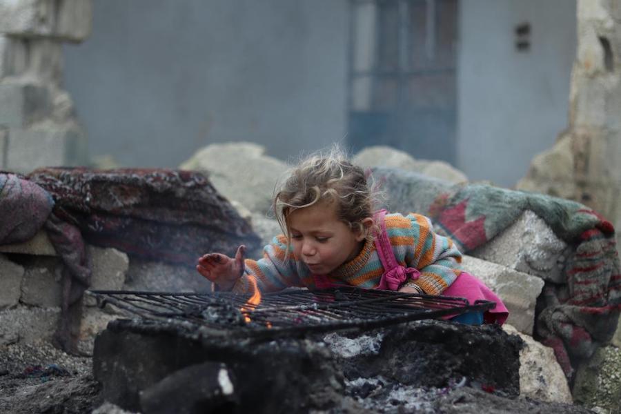 Khudr Al- Issa Mountaha, 3, warms her hands over the fire in front of their one-room home in Karm Al- Nazha neighborhood of east Aleppo. Photo: UNICEF/ Syria 2018/ 