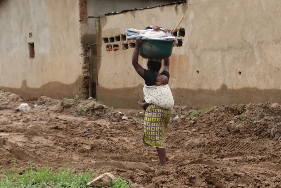 On January 29, 2020, a woman carries a basin full of the household goods she was able to salvage after her house was flooded in Bujumbura, Burundi. On January 29, 2020, a woman carries a basin full of the household goods she was able to salvage after her house was flooded in Bujumbura, Burundi.