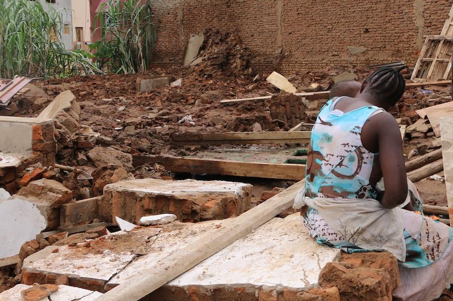 On January 29, 2020, a young mother sits in the ruins of her house, destroyed by heavy flooding in Burundi. 