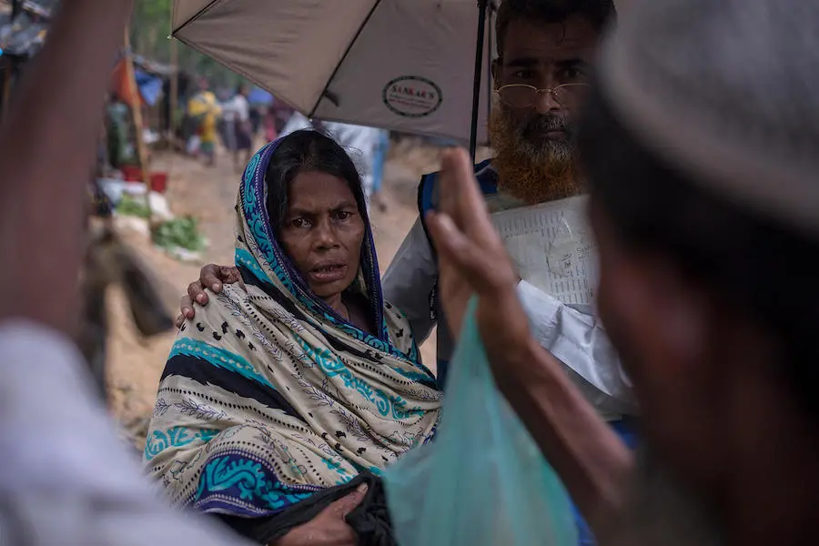 Lost in a vast sea of makeshift shelters, Rohingya refugee Johora carries her 4-day-old granddaughter through the Kutupalong refugee camp in Cox's Bazar, Bangladesh. Lost in a vast sea of makeshift shelters, Rohingya refugee Johora carries her 4-day-old granddaughter through the Kutupalong refugee camp in Cox's Bazar, Bangladesh.