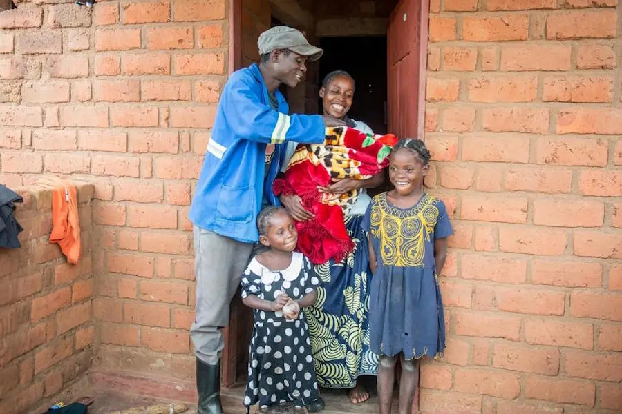 Family Standing in Front of House