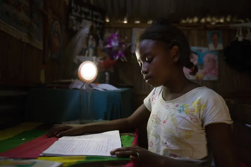 Odile studying by lantern light