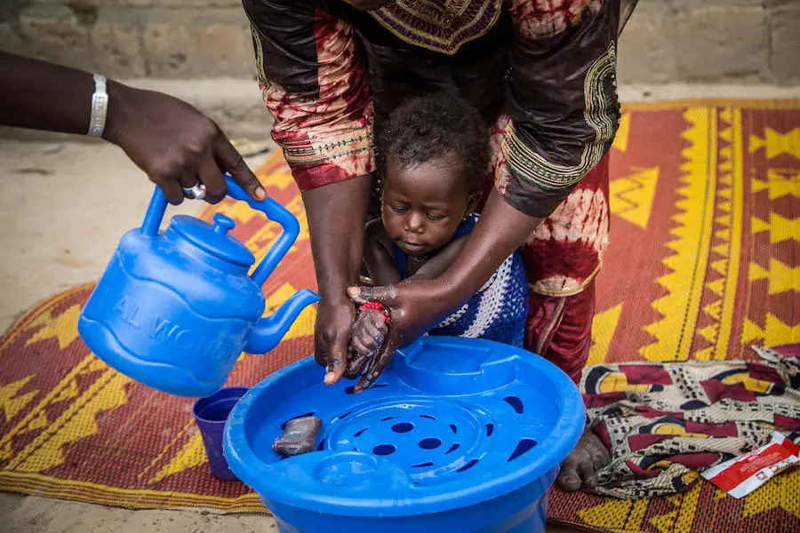 A mother washes her daughter's hands at the Bellefarendi health center in Timbuktu, Mali. UNICEF, handwashing, global handwashing day, WASH, Mali, diarrhea prevention
