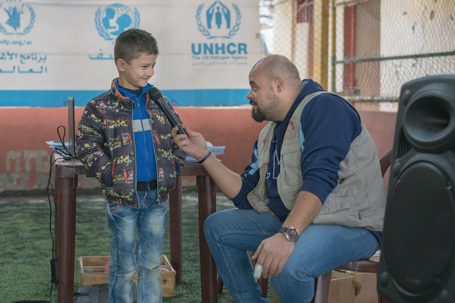Ali Cherro, right, from UNICEF partner PU-AMI Lebanon, answers questions about the LOUISE common card, which helps refugees access the benefits for which they are eligible.