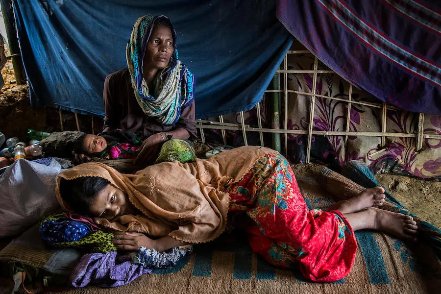 A boy carries his 4-day-old niece down a muddy slope in the sprawling Kutupalong camp for Rohingya refugees in Cox's Bazar Bangladesh in October 2017. Exhausted, 18-year-old Hazera is reunited with her newborn and her mother after giving birth in the UNICEF-supported birthing center in the Kutupalong camp for Rohingya refugees in Cox's Bazar, Bangladesh.