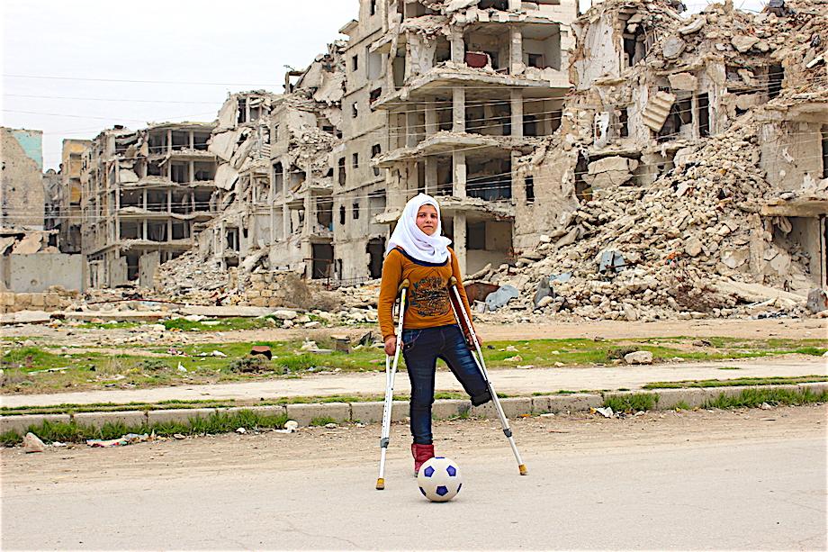 Girl with Crutches in Front of Destroyed Building