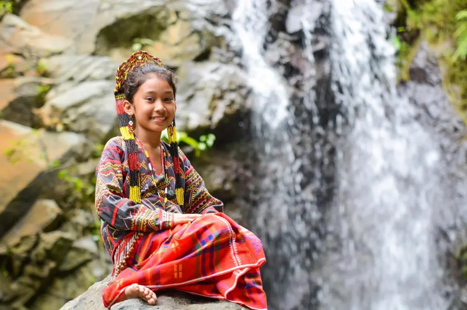 Girl Sitting in front of Waterfall