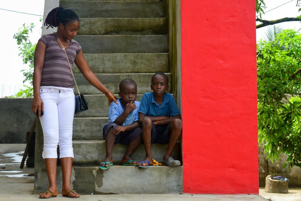 Caretaker Helen Morris consoles two boys who must remain in quarantine at an interim care center for children exposed to the Ebola virus, in Monrovia, Liberia.