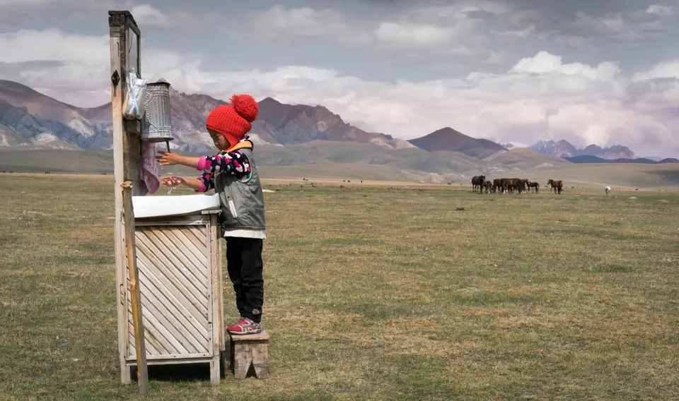 Five-year-old Ainazik demonstrates proper handwashing technique at an outdoor basin in a pasture in Naryn province, Kyrgyzstan. Five-year-old Ainazik demonstrates proper handwashing technique at an outdoor basin in a pasture in Naryn province, Kyrgyzstan.