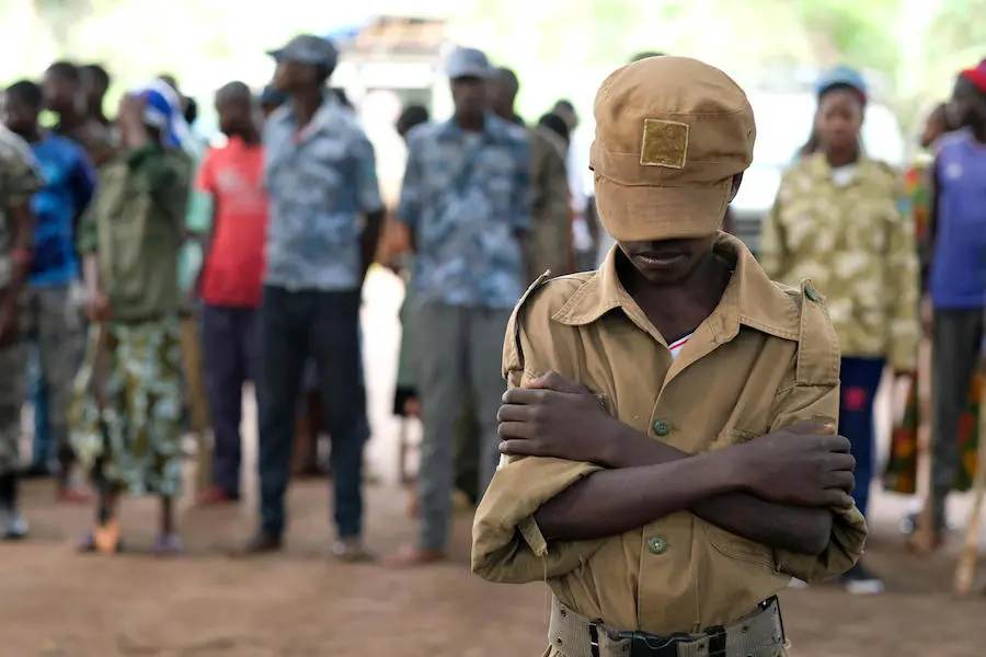 Jackson, 13, stands outside a ceremony to release children from the ranks of armed groups and start a process of reintegration in Yambio, South Sudan. Jackson, 13, stands outside a ceremony to release children from the ranks of armed groups and start a process of reintegration in Yambio, South Sudan.