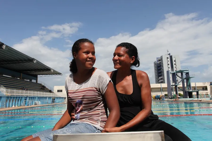 Two Women Sitting in Front of Pool