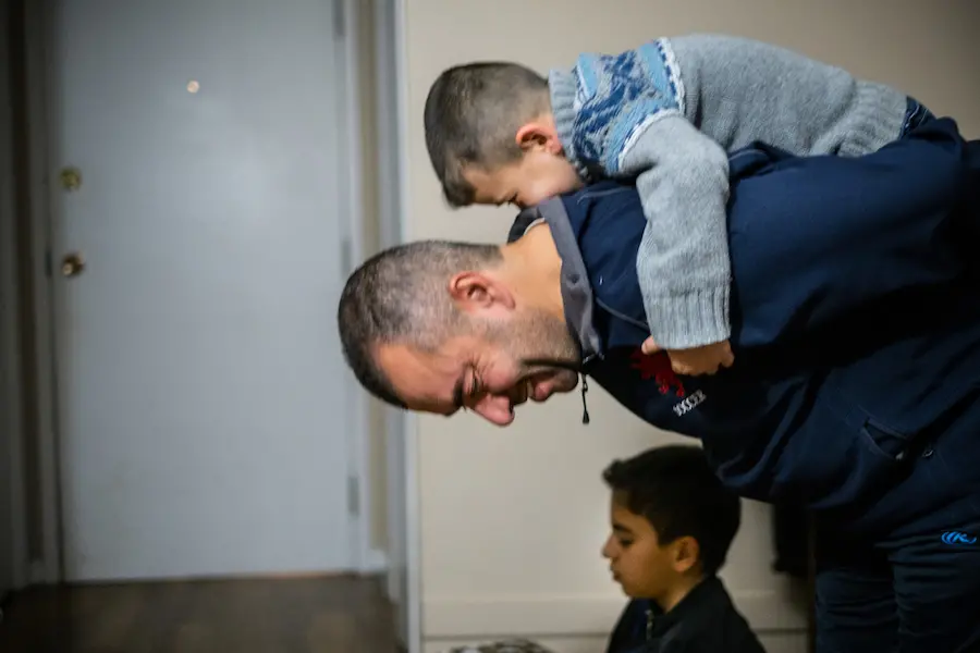 Syrian refugee Amjad Al Rashdan prays with his children at home in Charlottetown on Prince Edward Island, Canada. unicef, father's day, world refugee day, syrian refugee, canada