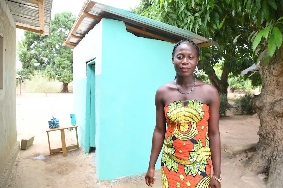 Emmanuelle Zroh, 26, stands outside her newly installed toilet in rural Côte d'Ivoire. unicef, sanitation, côte d'ivoire, toilets