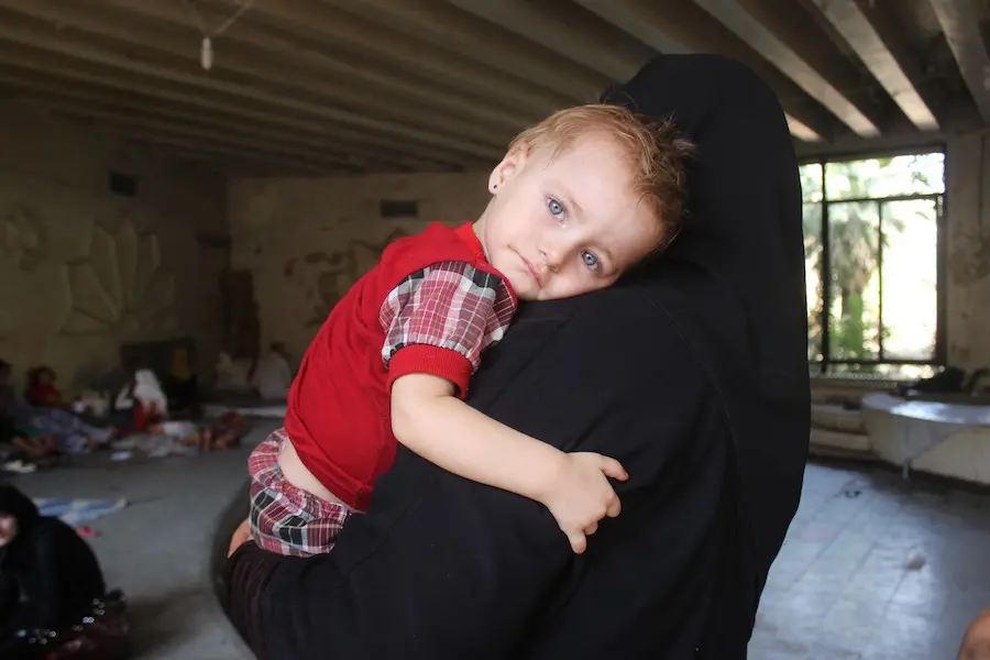 Woman Holding Child Against Shoulder
