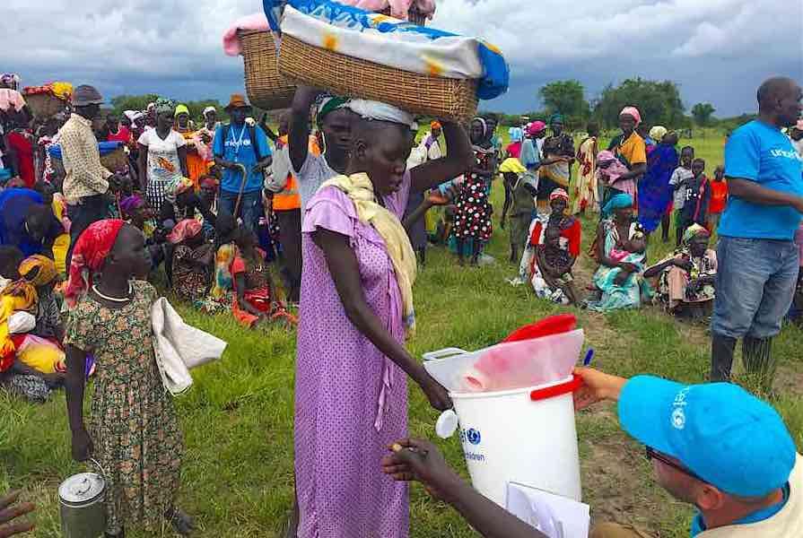 UNICEF staff distribute WASH supplies, including buckets, soap and water purifiers, to pregnant women and lactating mothers, during a Rapid Response Mechanism (RRM) mission in Kaikuiny village, Jonglei State, South Sudan, Friday 25 August 2017. UNICEF and