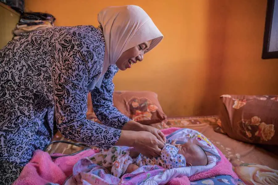 Laticia, 20 days old, is checked by midwife Widyani during a home care visit in Batu, Indonesia. Widyani also delivered the child. Laticia, 20 days old, is checked by midwife Widyani during a home care visit in Batu, Indonesia. Widyani also delivered the child.