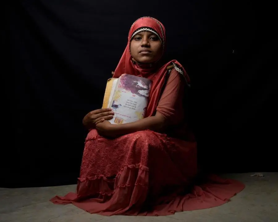 Rohingya refugee Tasmin, 14, holds her favorite book of poetry at a UNICEF-supported Child-Friendly Space in Kutupalong refugee camp, Cox's Bazar, Bangladesh in 2018. UNICEF, Rohingya, Bangladesh