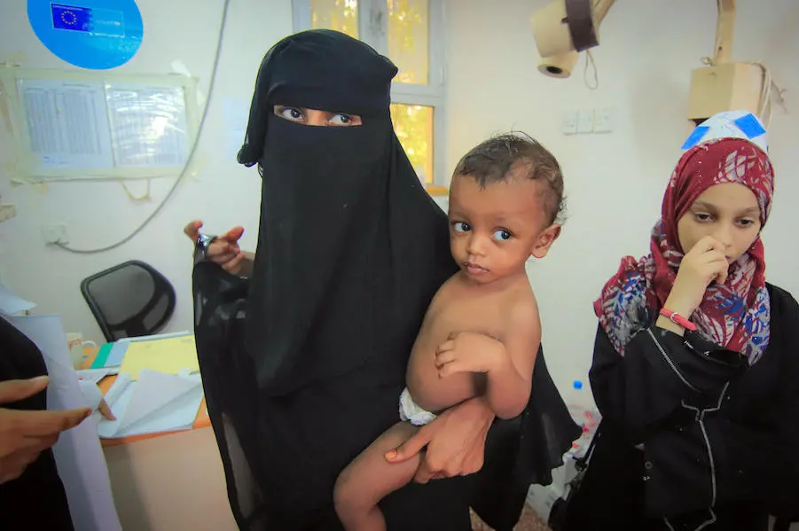 A woman holds her baby at the UNICEF-supported Alqatee'a Health Center in Aden, Yemen on June 25, 2018. unicef, yemen, humanitarian crisis, al hudaydah, hodeidah