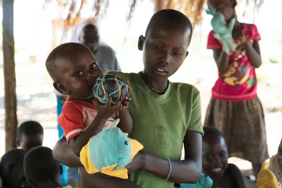 South Sudanese refugee baby playing with locally made sponge ball in Uganda's Yumbe district. South Sudanese refugee baby playing with locally made sponge ball in Uganda's Yumbe district.