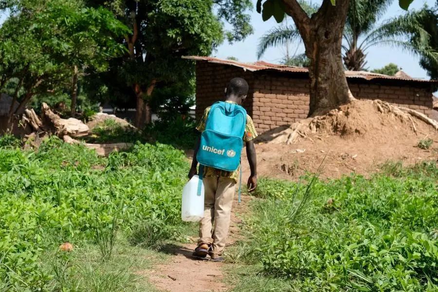 Alex, 9, brings a jerry can filled with safe water to his family's home near Yambio, South Sudan in 2018. The water comes from a solar-powered pump supported by UNICEF. Alex, 9, brings a jerry can filled with safe water to his family's home near Yambio, South Sudan in 2018. The water comes from a solar-powered pump supported by UNICEF.