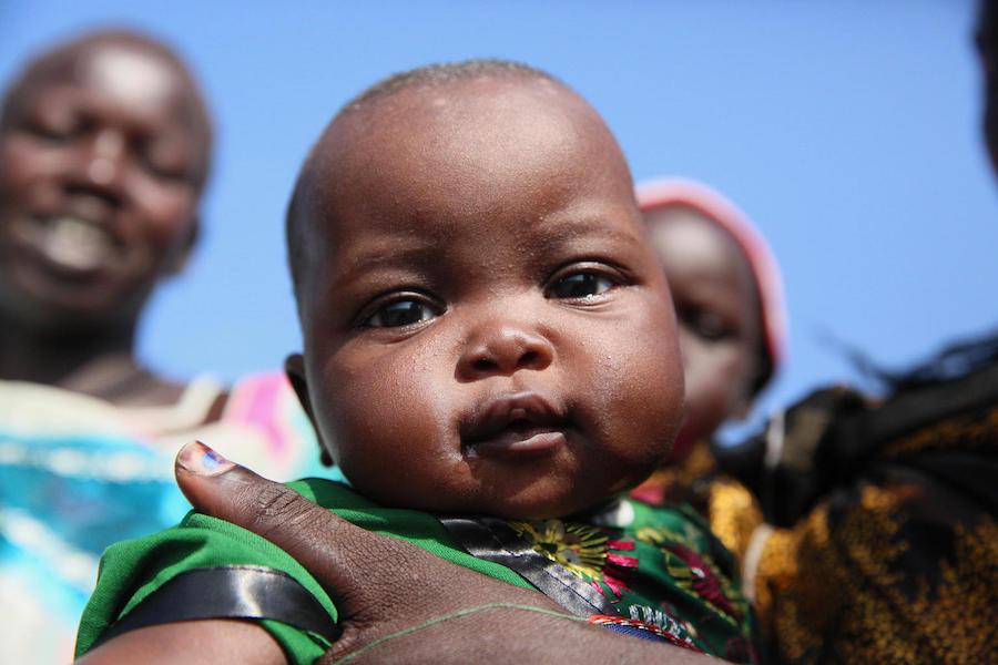 A baby waits with her family for nutrition screening and vaccinations provided by UNICEF and partners in Jonglei State, South Sudan on July 22, 2018.